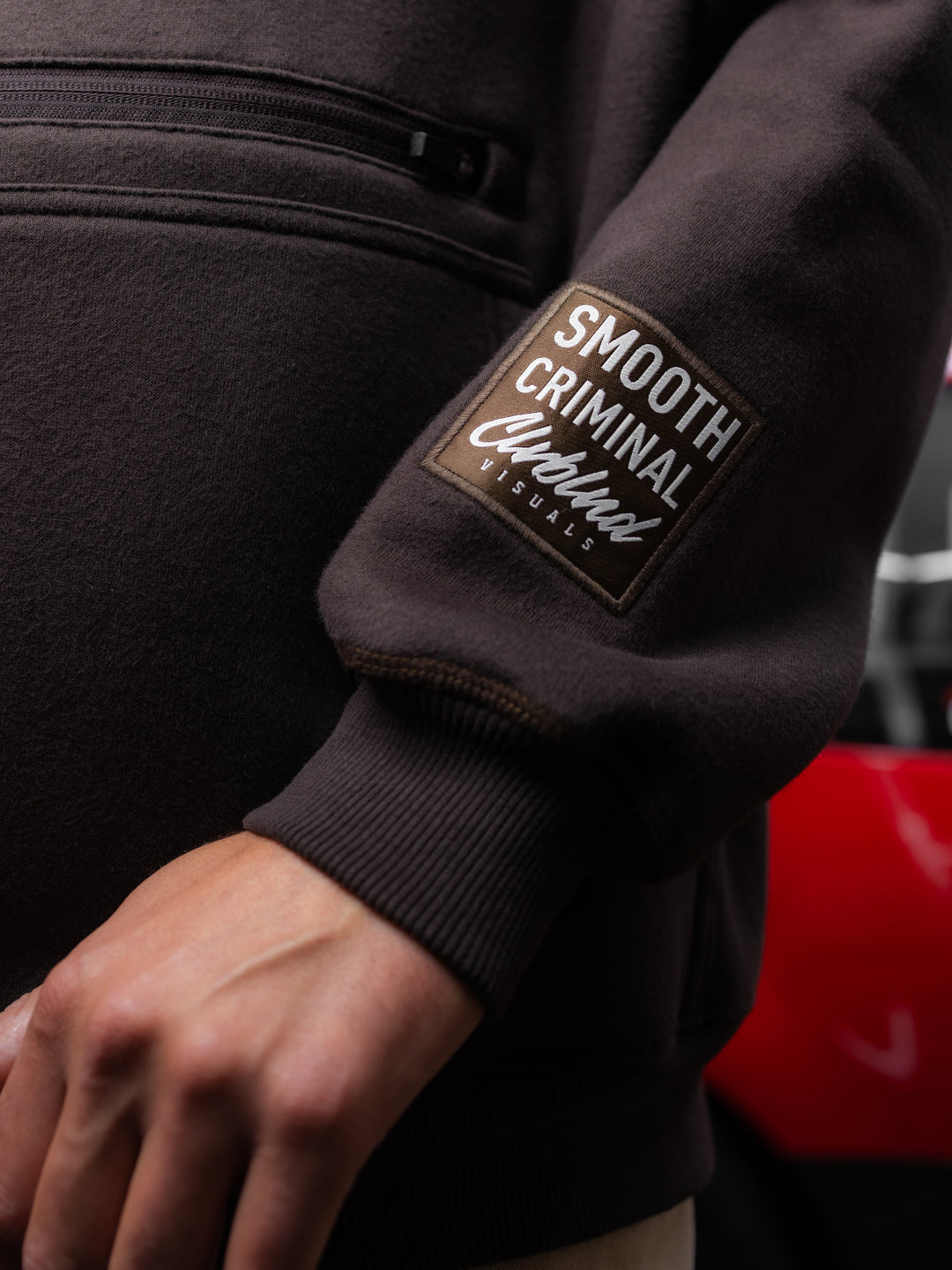 Detailaufnahme des Smooth Criminal Patches am Ärmel des Falling Leaves Teddy Hoodies